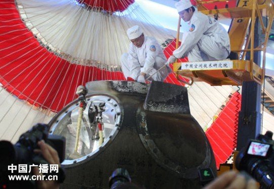 工作人員進(jìn)入返回艙,取出艙內(nèi)物品(中廣網(wǎng)記者劉夢(mèng) 攝)