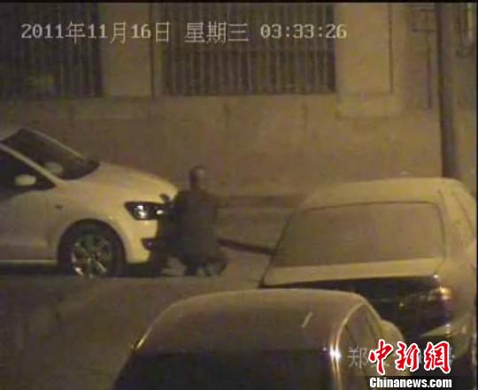 視頻監(jiān)控顯示，該男子正在撬盜車牌。