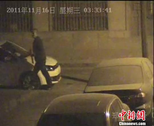 視頻監(jiān)控顯示，該男子正在撬盜車牌。