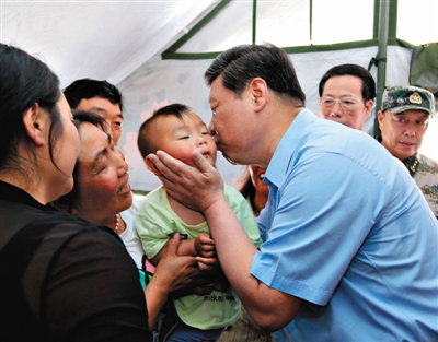 2013年5月，習近平赴蘆山地震災區(qū)考察，在蘆山縣體育館安置點一帳篷內(nèi)親撫一小孩�！⌒氯A社發(fā)