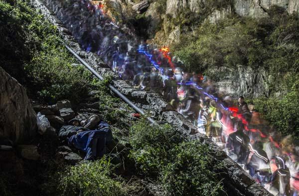 游客裹軍大衣夜登泰山看日出 躺路邊山石上睡覺
