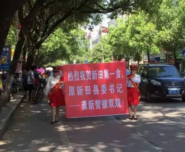 6月28日上午，一張照片在湖南省永州市新田縣的微信朋友圈瘋傳。照片上，兩名身著儀仗隊(duì)服飾的老婦抬著一塊宣傳牌，身后緊跟隊(duì)伍的，有抬著相同的牌子的老人，也有老人敲打樂器。